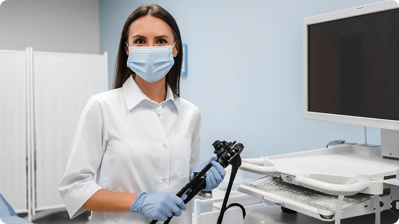 Medical professional holding an endoscope in an examination room