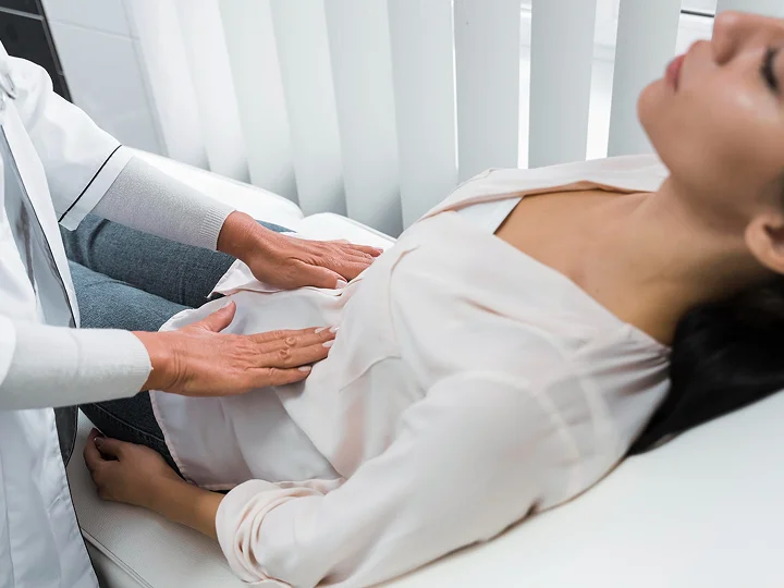 Healthcare provider performing an abdominal examination on a patient